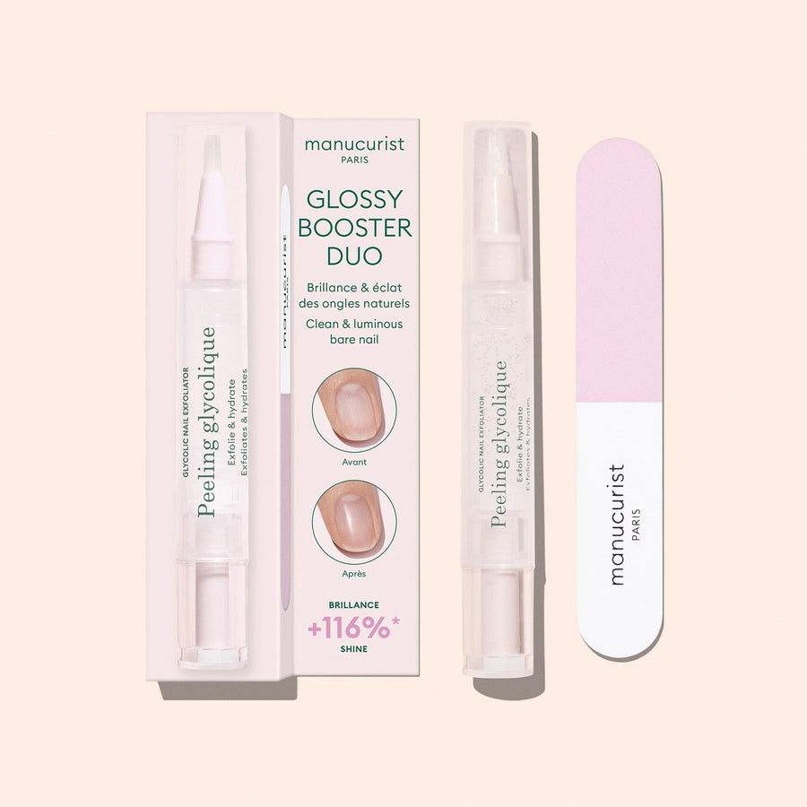 The Glossy Booster Duo by Manucurist—featuring a gentle nail exfoliator and a pink and white nail file—stands upright on a light beige background, perfect for achieving glossy nails.