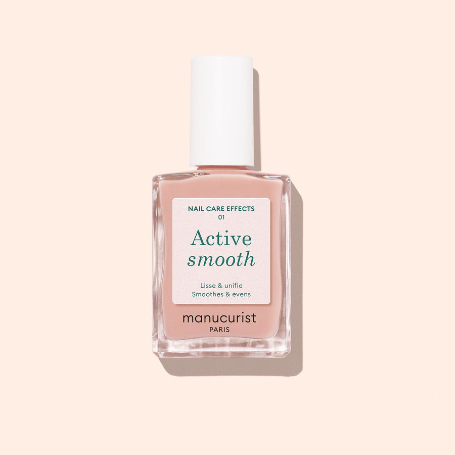 A bottle of Manucurist Active™ Smooth 01 nail care polish with a white cap is displayed against a pale peach background, showcasing this plant-based CC Polish Treatment formulated to perfect and protect your nails.