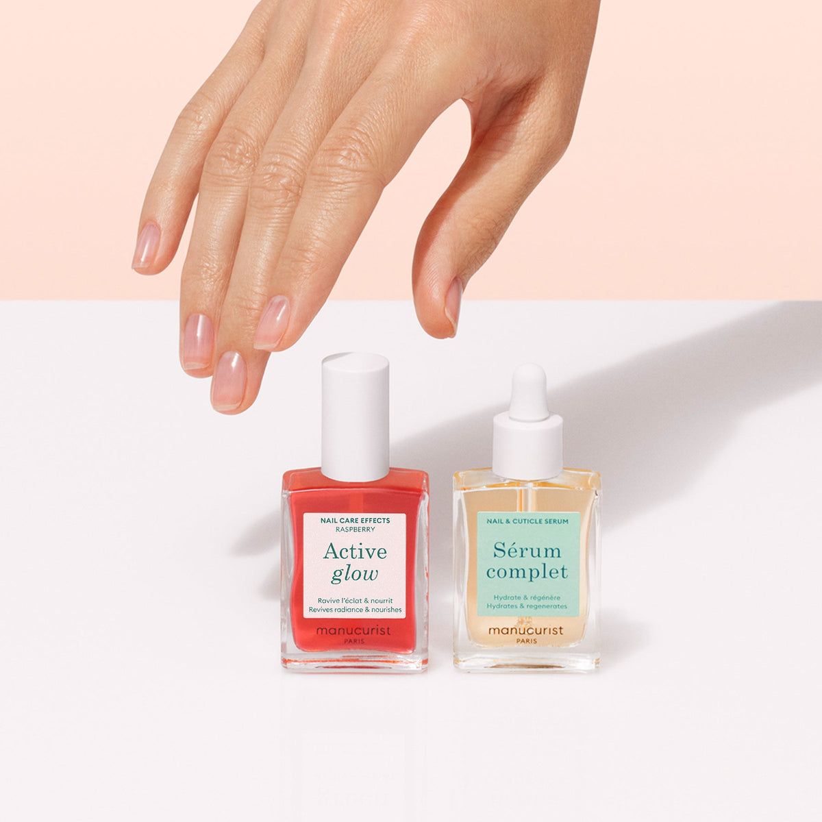 The Manucurist Healthy Glow Duo features two nail serums—Active Glow (pink) and Sérum Complet (clear)—displayed on a light beige background, designed to nourish and beautify nails.