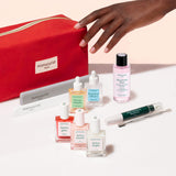 The Manucurist Ultimate Active Manicure Kit features a vibrant red pouch containing a comprehensive nail care set—including a buffer, file, cuticle remover pen, metal tool, three polish bottles, base coat and top coat bottles, and nail polish remover—all beautifully arranged on a light background for healthy nails.