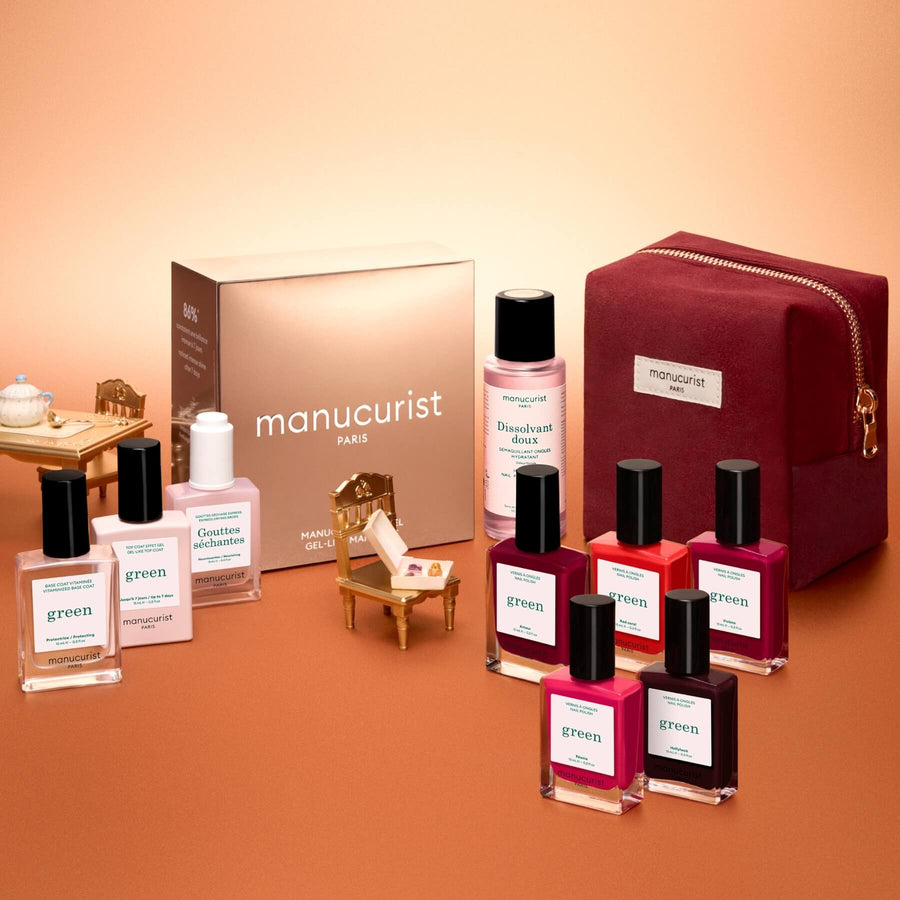 Manucurist’s Green™ Super Starter Kit Gift Set features a pink pouch, a brown box, six naturally derived nail polishes in assorted shades, and four smaller nail care bottles—everything you need for a gel-like manicure—beautifully arranged on a warm beige background.