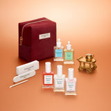 The Manucurist Active™ Starter Kit Gift Set features everything you need to elevate your manicure routine: three nail polishes, two cuticle oils, two nail files, and a wooden cuticle stick, all beautifully packaged in a burgundy velvet pouch and arranged on a soft peach background.