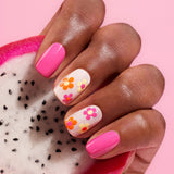 Four bottles of Manucurist's Flower Love! are displayed on and around a pink textured block, with a close-up inset of the Dotting Tool on a light pink background—perfect inspiration for your springtime nail art.