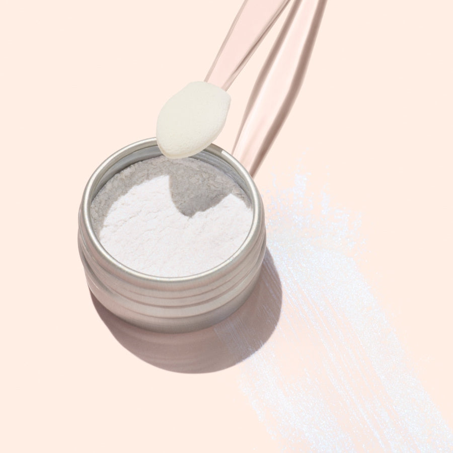 A round metal tin of Manucurist Blue Glazed Powder, a fine white manicure powder, viewed from above on a light beige background.