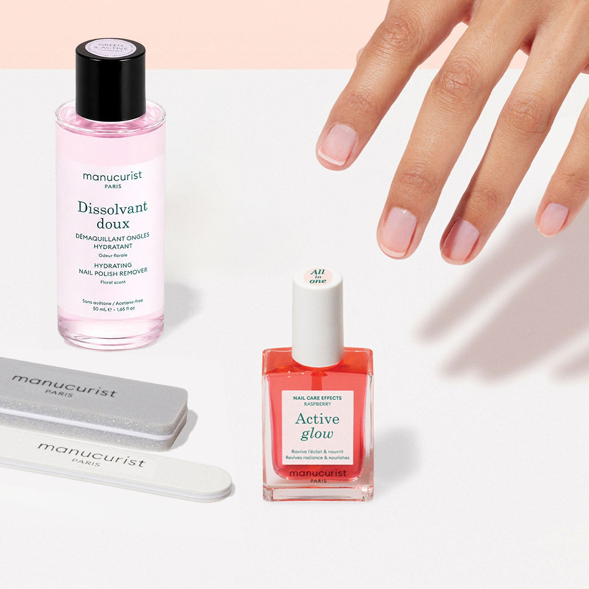 The Manucurist Active Discovery Kit features two nail files, a pink bottle of nail polish labeled "Active Glow," and a pink bottle of nail polish remover labeled "Dissolvant Doux," all beautifully arranged on a light beige background—essential tools for achieving a flawless manicure and elevating your daily nail care routine.