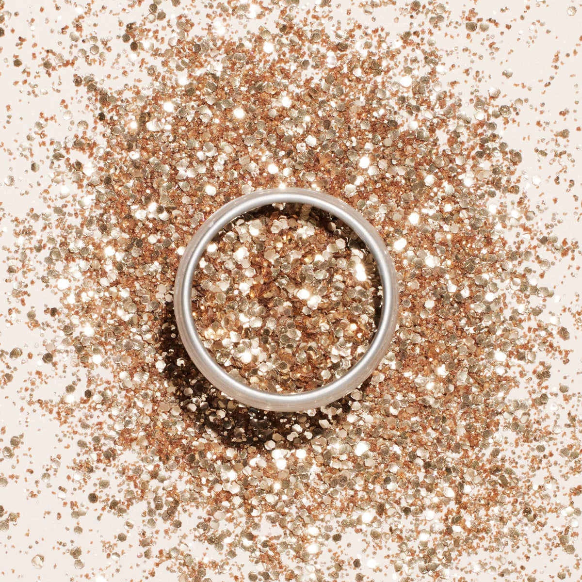 A round container of Manucurist Rose Gold Biodegradable Glitter, perfect for nail art, sits on a light beige background and casts a soft shadow.