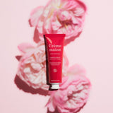 A red tube and a brown box of Everyday Rose Hand Cream - Cosmos Organic by Manucurist are shown on a pink background, both featuring white and pink text.
